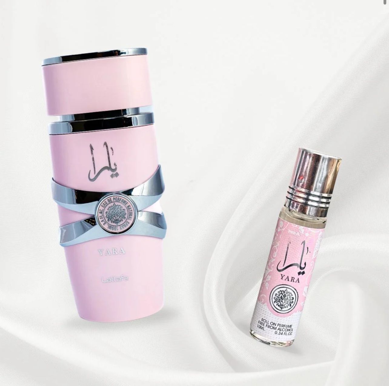 Lattafa Yara perfume set featuring a soft pink spray bottles with silver accents and a matching roo-on bottle, place on white fabric background for an elegant presentation.