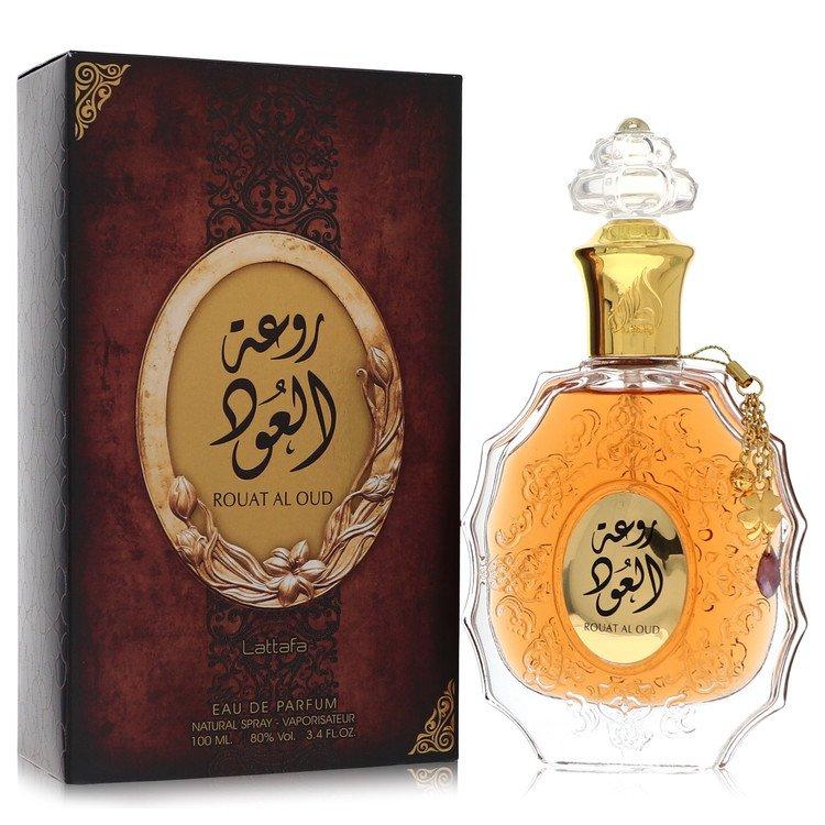 A luxurious bottle of Rouat Al Oud by Lattafa Perfumes placed beside its elegant brown packaging, showcasing a golden fragrance bottle with ornate detailing and a clear decorative cap, ideal for both men and women.