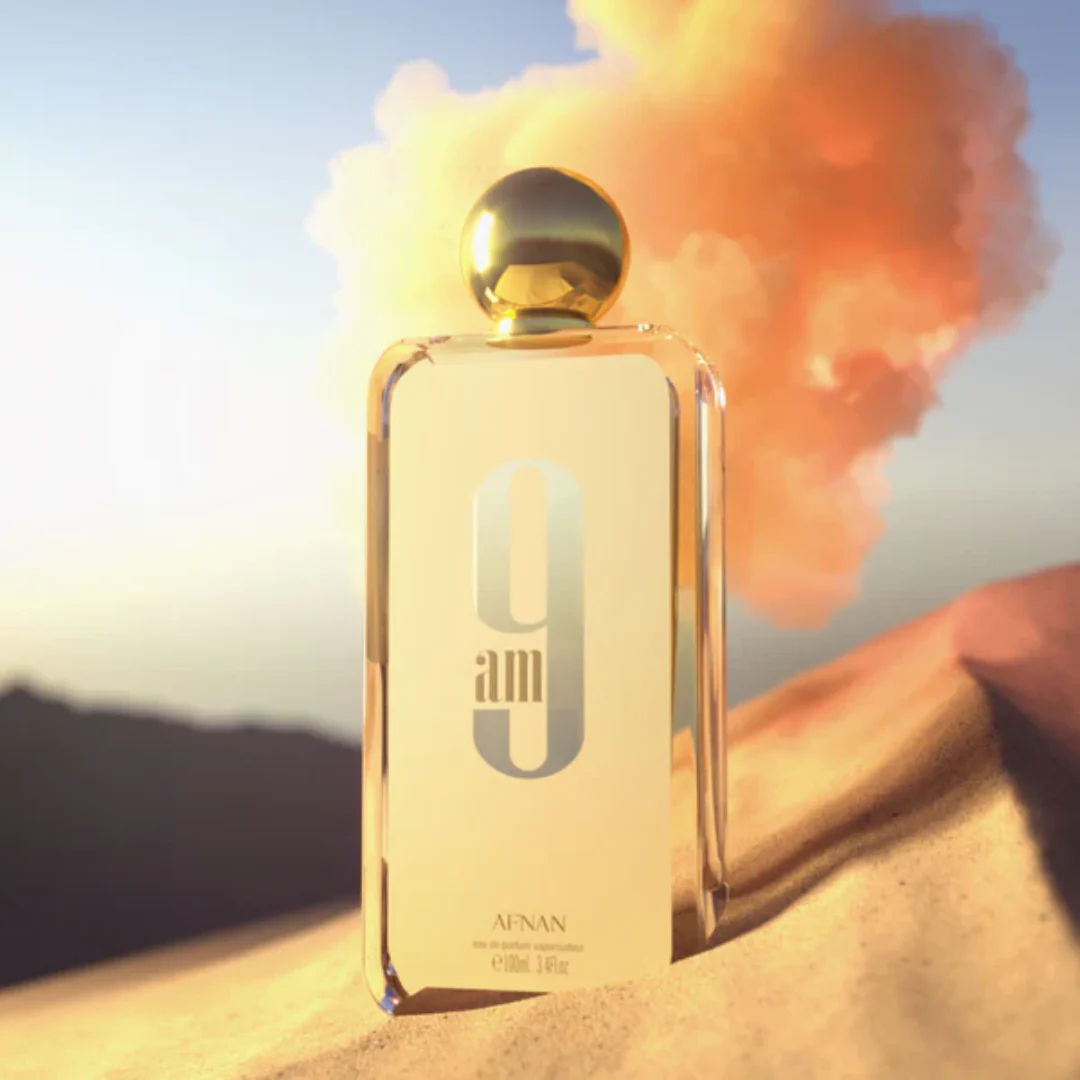Afnan 9am perfume bottle showcased in a dramatic desert sunrise - Capturing the essence of freshness and sophistication.