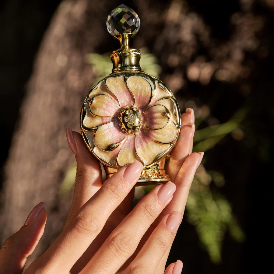 Amaali perfume bottle by Swiss Arabian, featuring a beautiful floral design with intricate golden details, held gracefully in hand.