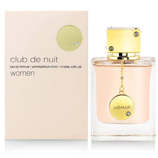 A sleek bottle of Club De Nuit for Women EDP (105ML) by Armaf with an elegant gold cap, presented next to its matching beige and gold box.