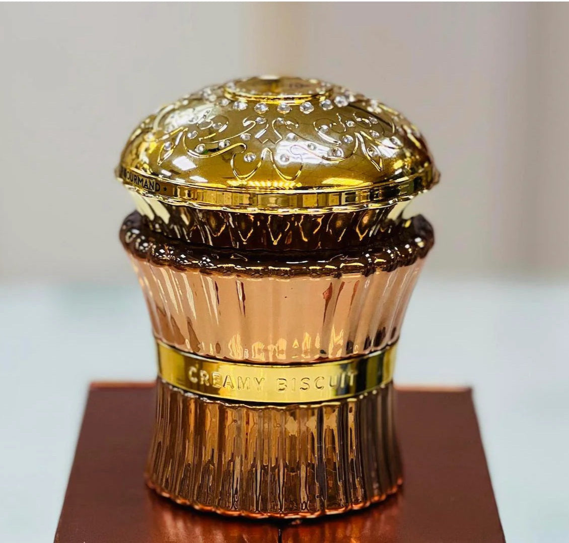 Creamy Biscuit perfume by Paris Corner in a golden cupcake-shaped bottle on display, luxurious gourmand fragrance for women.