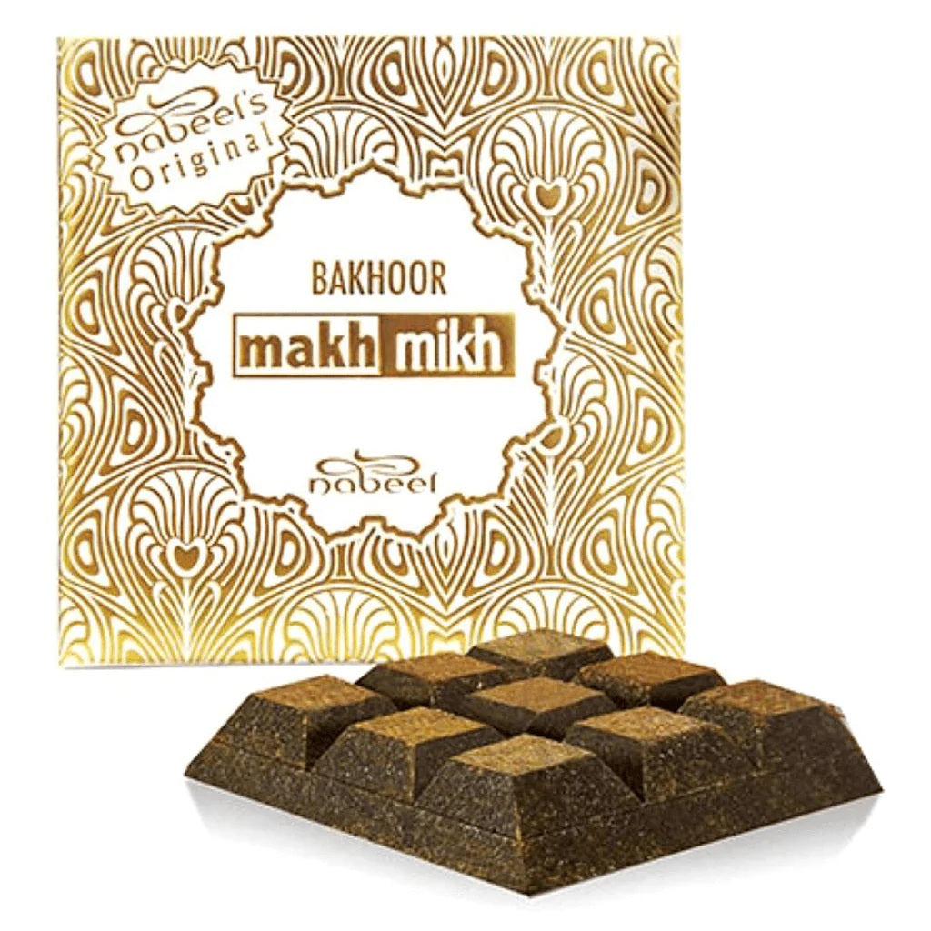 Makh Mikh Bakhoor 40 GMS by Nabeel, featuring a beautifully designed gold and white box with intricate patterns and premium bakhoor pieces for a luxurious aromatic experience.