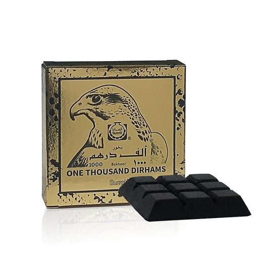 One Thousand Dirhams Bakhoor by Surrati, a premium 40g Arabian incense with a unique chocolate-infused oud fragrance, displayed in luxurious gold and black packaging with a falcon design.