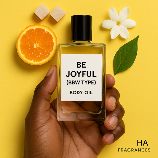 A bottle of Be Joyful (BBW Type) Body Oil held by a dark-skinned hand, surrounded by fresh clementines, sugar crystals, and jasmine flowers, with the HA Fragrances logo in the corner.