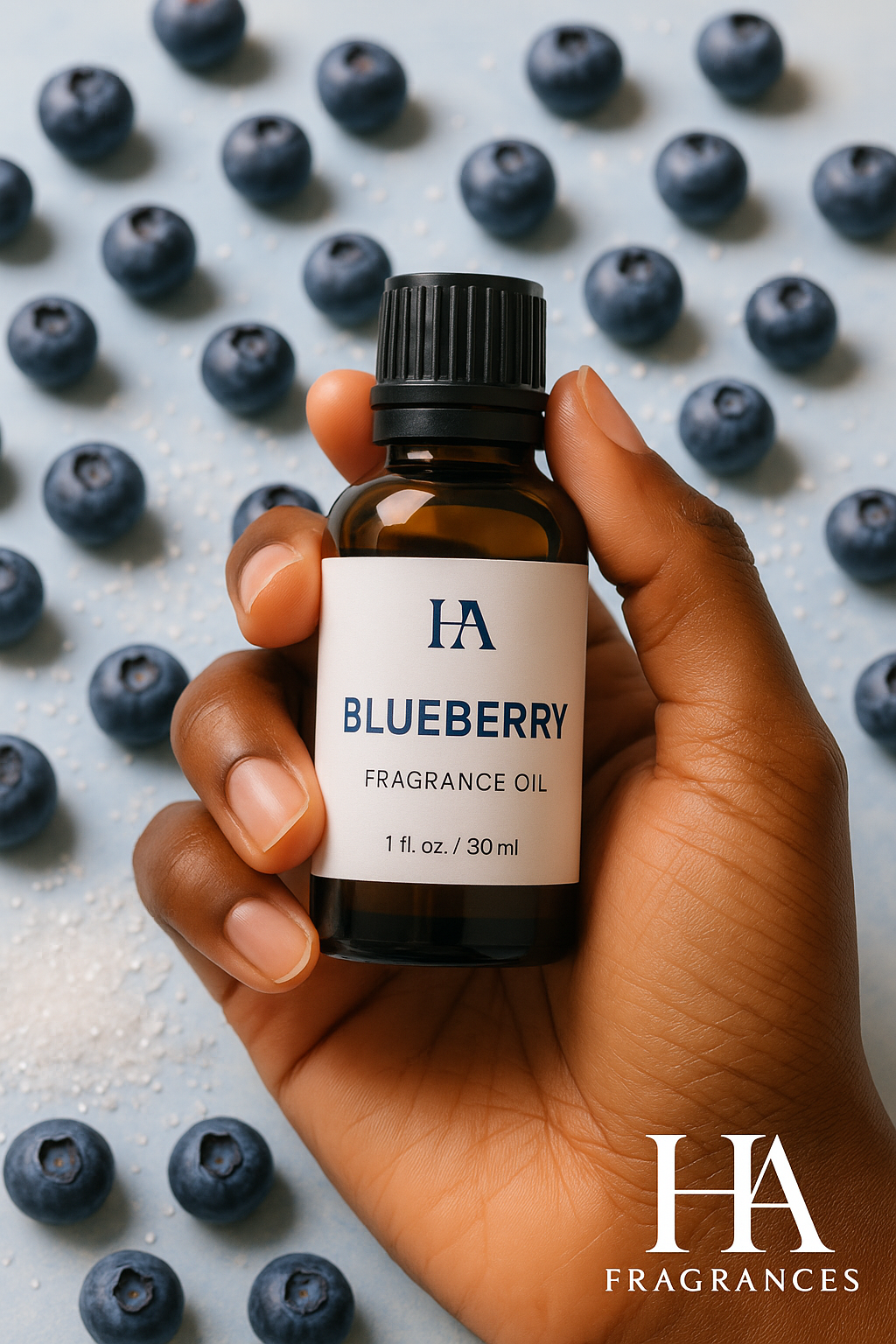 A dark-skinned hand holding a bottle of HA Fragrances Blueberry Fragrance Oil, with fresh blueberries and sugar crystals in the background.