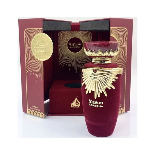 Lattafa Sakeena Eau De Parfum 100ml bottle displayed in a luxurious red and gold gift box with sunburst accents and Arabic calligraphy.