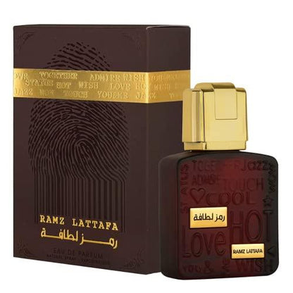 Lattafa Ramz Gold Eau de Parfum 3.4oz, featuring a luxurious dark brown and gold bottle with matching elegant packaging, showcasing intricate embossed details.