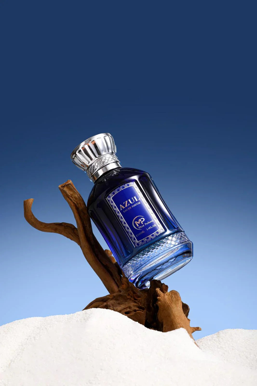 Mast Azul Eau de Parfum by Bharara displayed on driftwood with ocean-blue background – luxury blue bottle symbolizing freshness and clean aquatic scent.