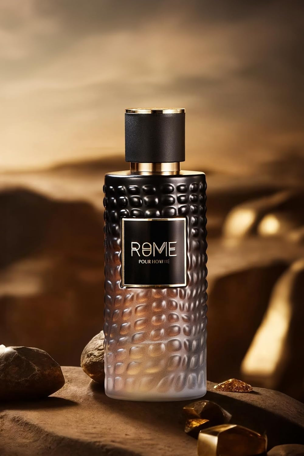 Rome Pour Homme Eau De Parfum 100ML – a sleek black and gold men's fragrance bottle set against a rugged, golden desert landscape, symbolizing strength and elegance.