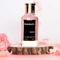 Bharara Rose Eau de Parfum 100ML bottle on a rustic wooden platform surrounded by soft pink rose petals, showcasing a luxurious feminine fragrance.