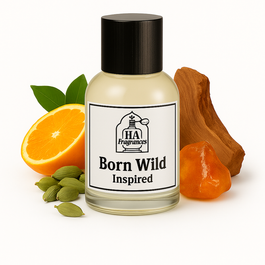 Ed Hardy Born Wild Inspired cologne oil by HA Fragrances in a clear glass bottle, surrounded by orange slices, cardamom pods, black pepper, sandalwood, and amber resin on a white background.