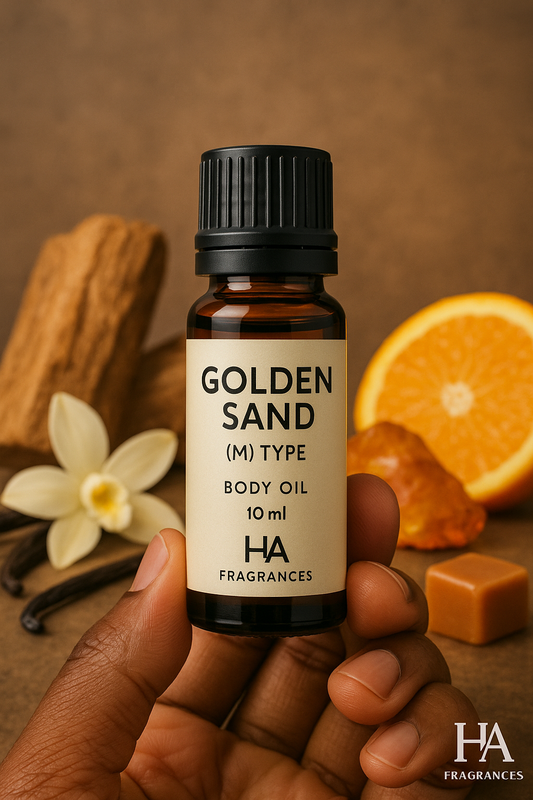 Hand holding HA Fragrances Golden Sand (M) Type Body Oil 10ml bottle, surrounded by vanilla flower, cinnamon, orange slice, caramel, and amber – warm and exotic men's fragrance oil.