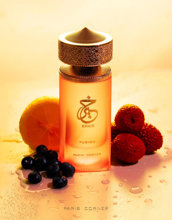Khair Fusion Lyche Eau De Parfum bottle by Paris Corner surrounded by lychee, lemon, and berries on a golden background