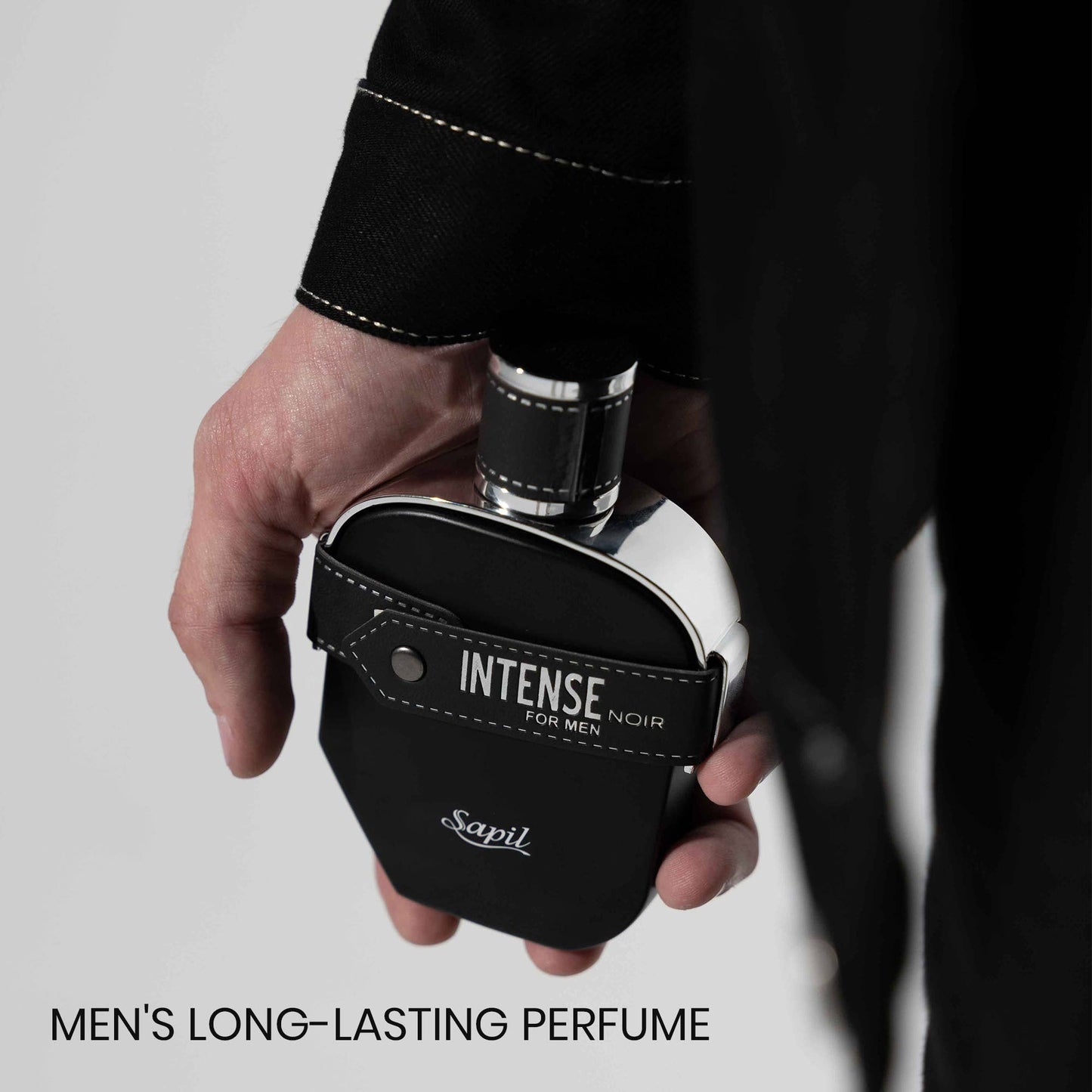 Hand holding Sapil Intense Noir for Men black perfume bottle